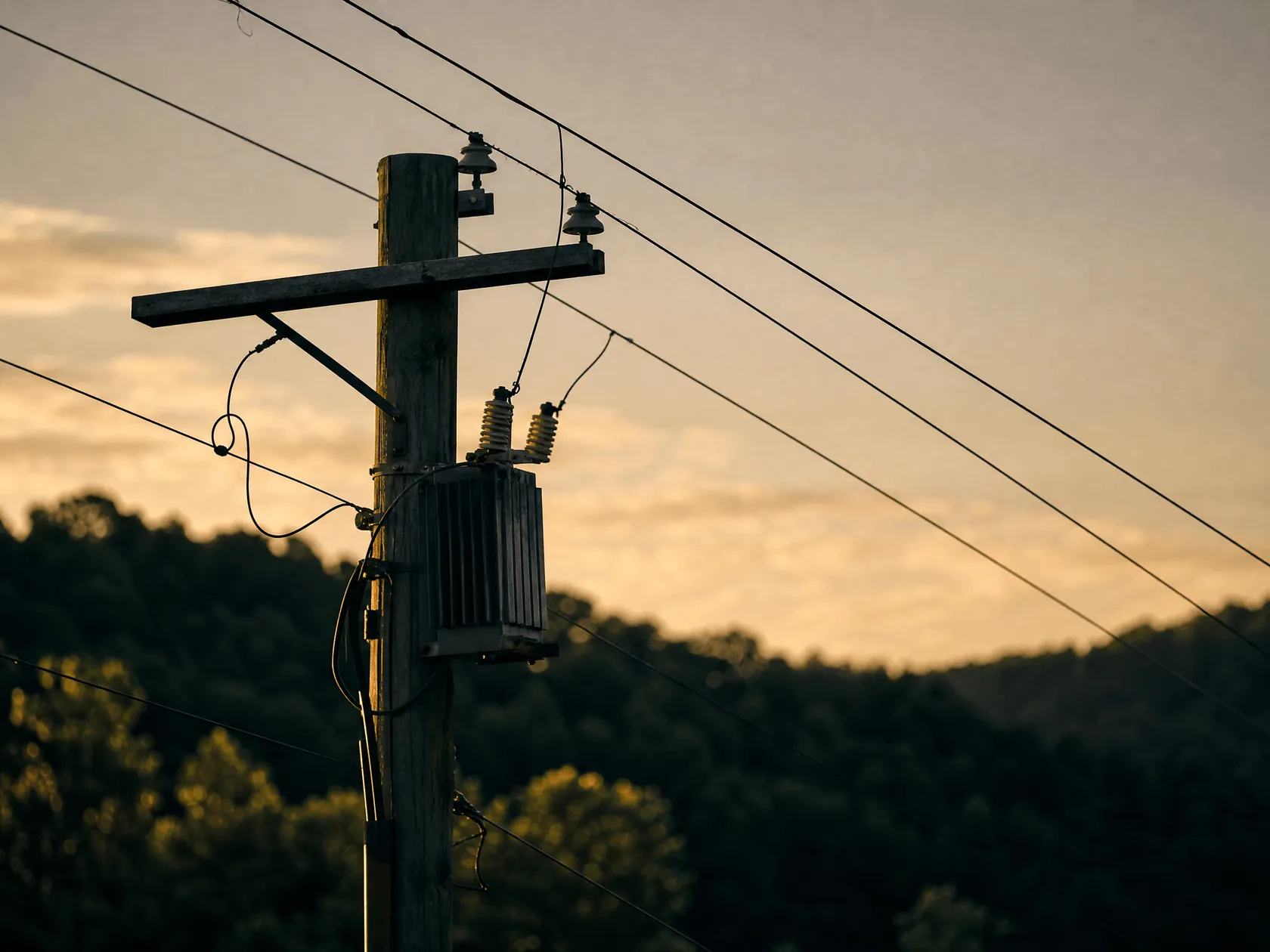 Overhead electricity distribution lines and a pole-mounted transformer against an open sky